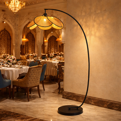 modern rattan floor lamp with an arched metal stand and woven rattan shade.